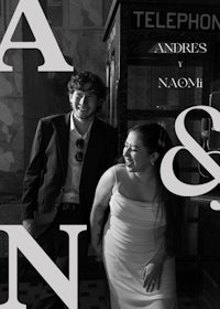 a black and white photo of a man and woman standing next to a telephone